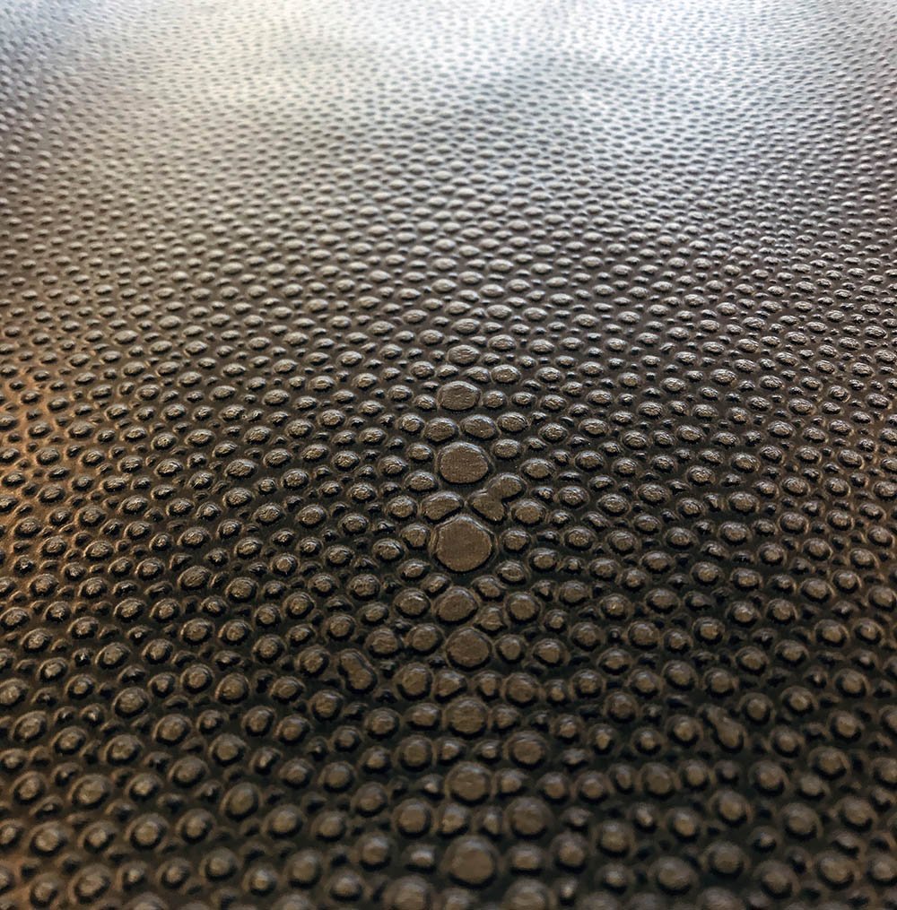 Hand-carved surface texture on architectural panel with chisel marks visible